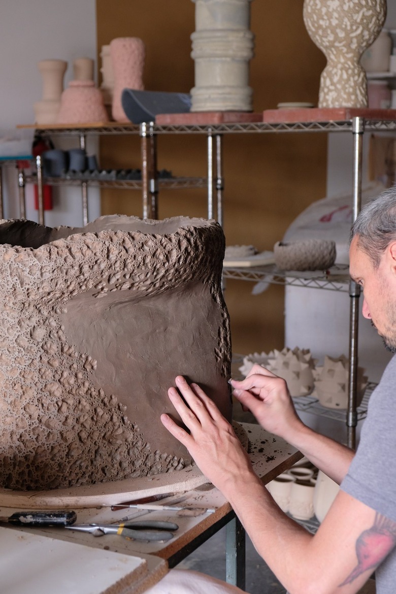 person creating ceramic piece in a studio