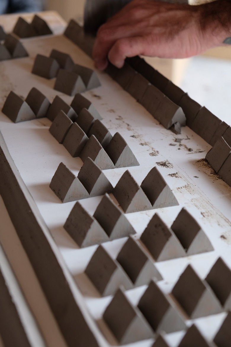 close-up of clay pieces and hand in the background