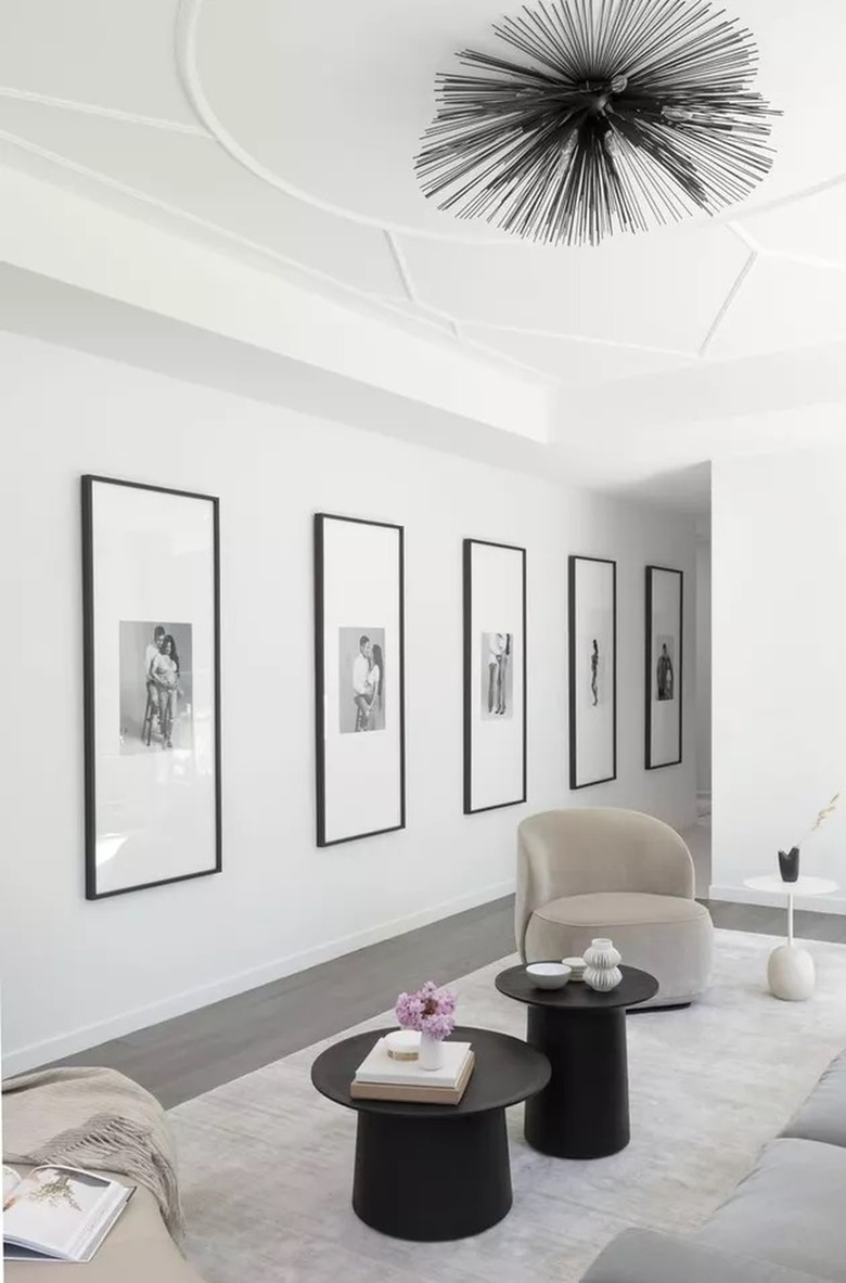 Art gallery style minimalist livingroom with black statement semi-flush light fitting