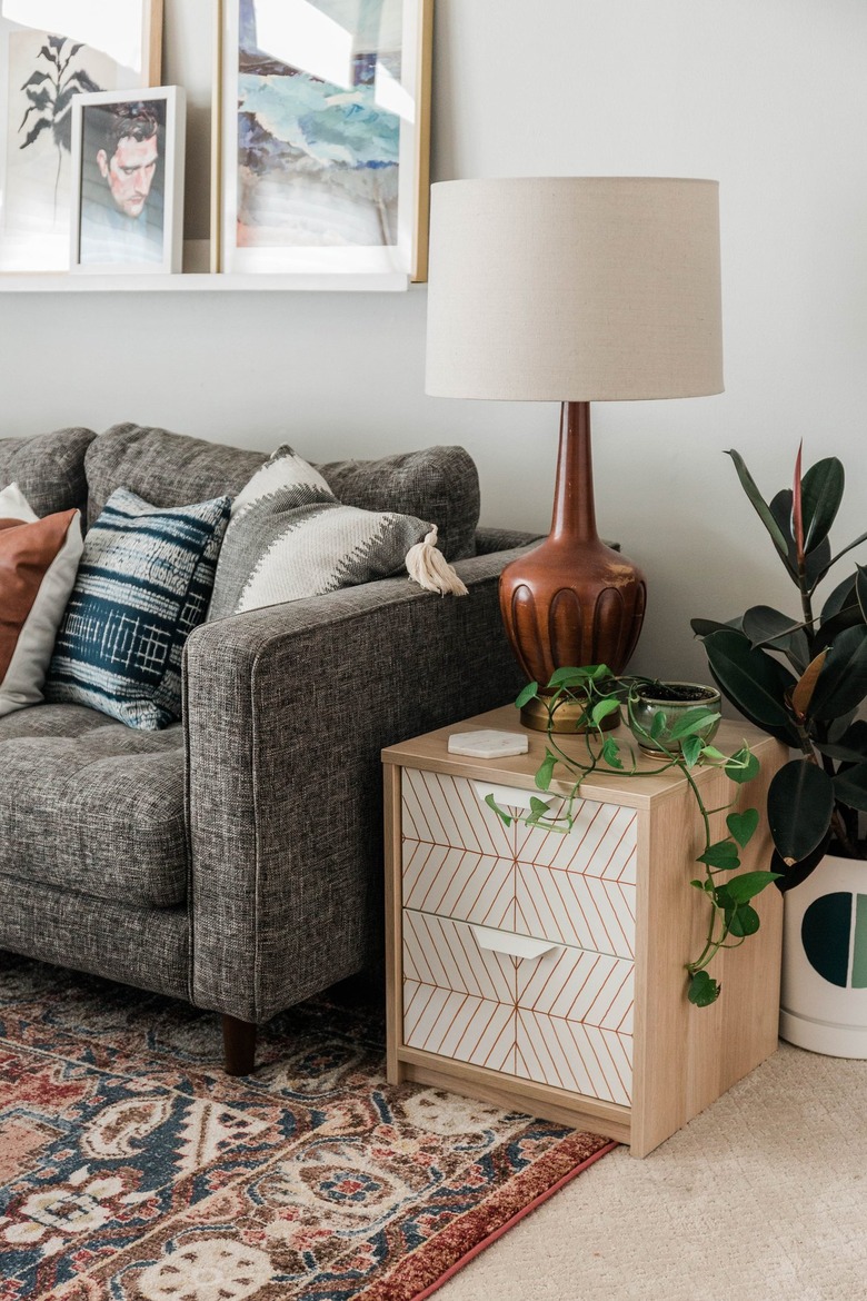 Scandinavian white and neutral nightstand with striped pattern with plant on Persian rug
