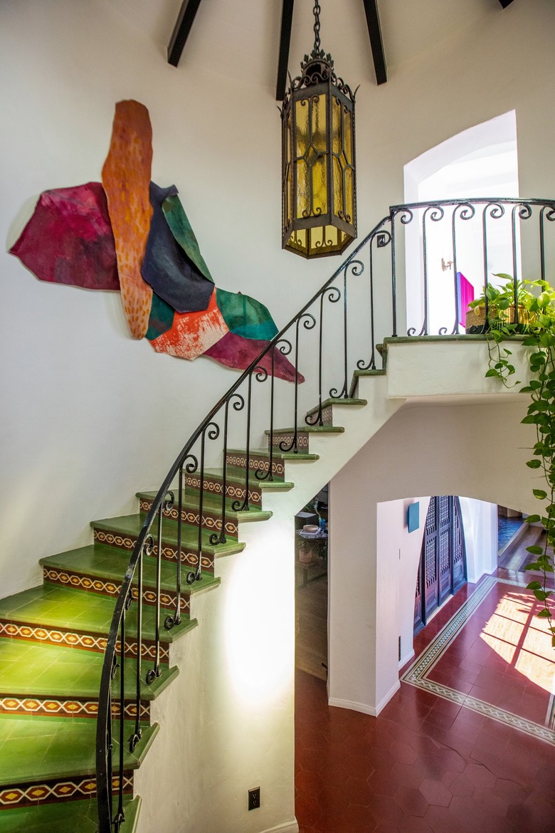 staircase covered in original green tile with steel railing