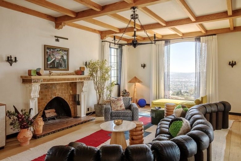 living room with curved sofa and brick fireplace