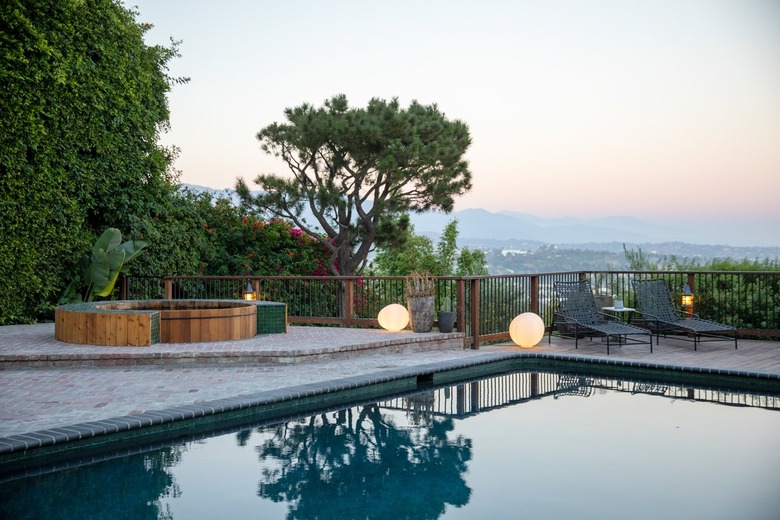 outdoor space with cedar hot tub near pool overlooking the city