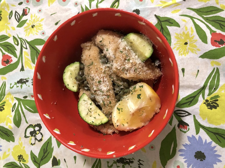 chicken piccata in a red dish on floral tea towel