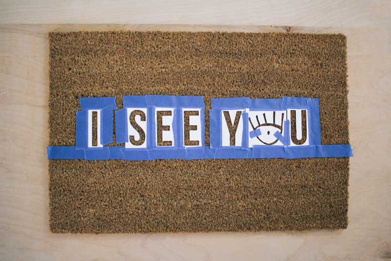 Letter stencils taped to doormat