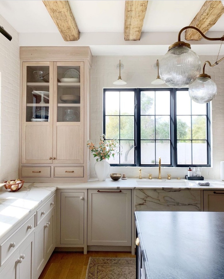 marble apron front sink next to cream cabinets in traditional kitchen