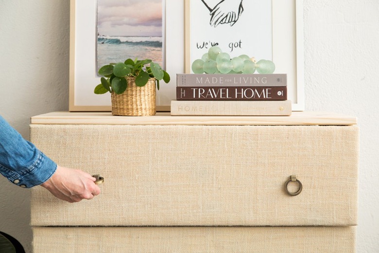 Person pulling a round handle of an IKEA Tarva dresser