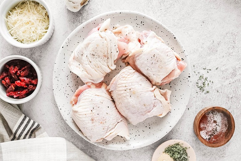 Sprinkle spices on chicken thighs