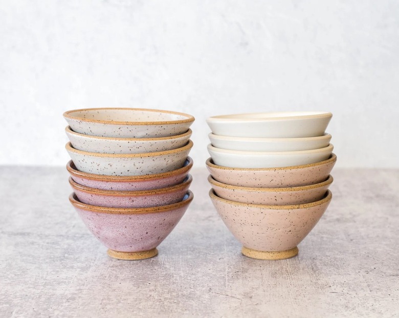 Two stacks of small angled bowls in pink
