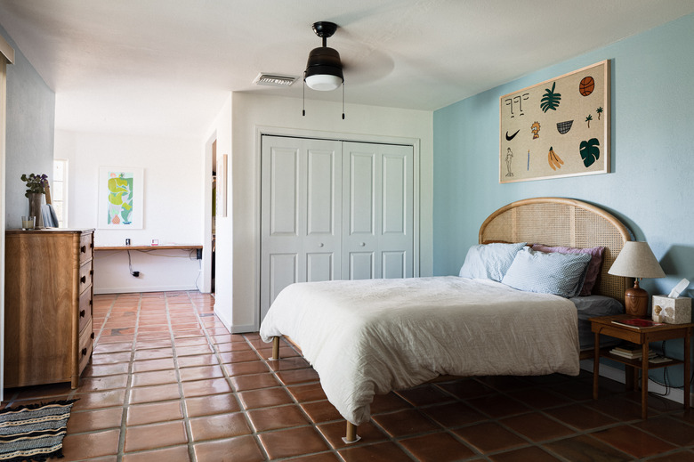 Saltillo tile floor in bedroom with ceiling fan