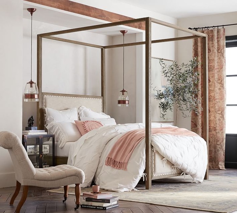 glass pendants hanging either side of timber frame canopy bed