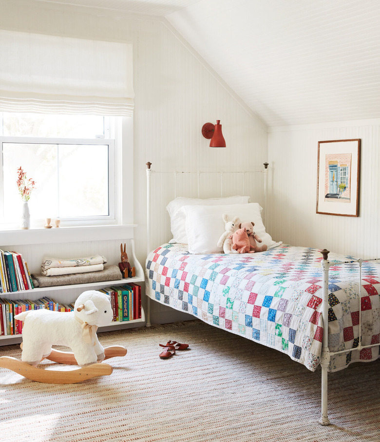 small red industrial wall light above single bed