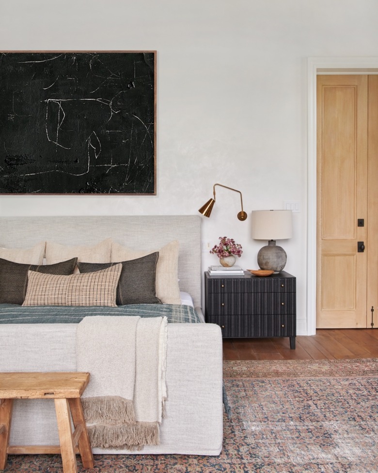 gold brass wall light and cement table lamp in farmhouse bedroom