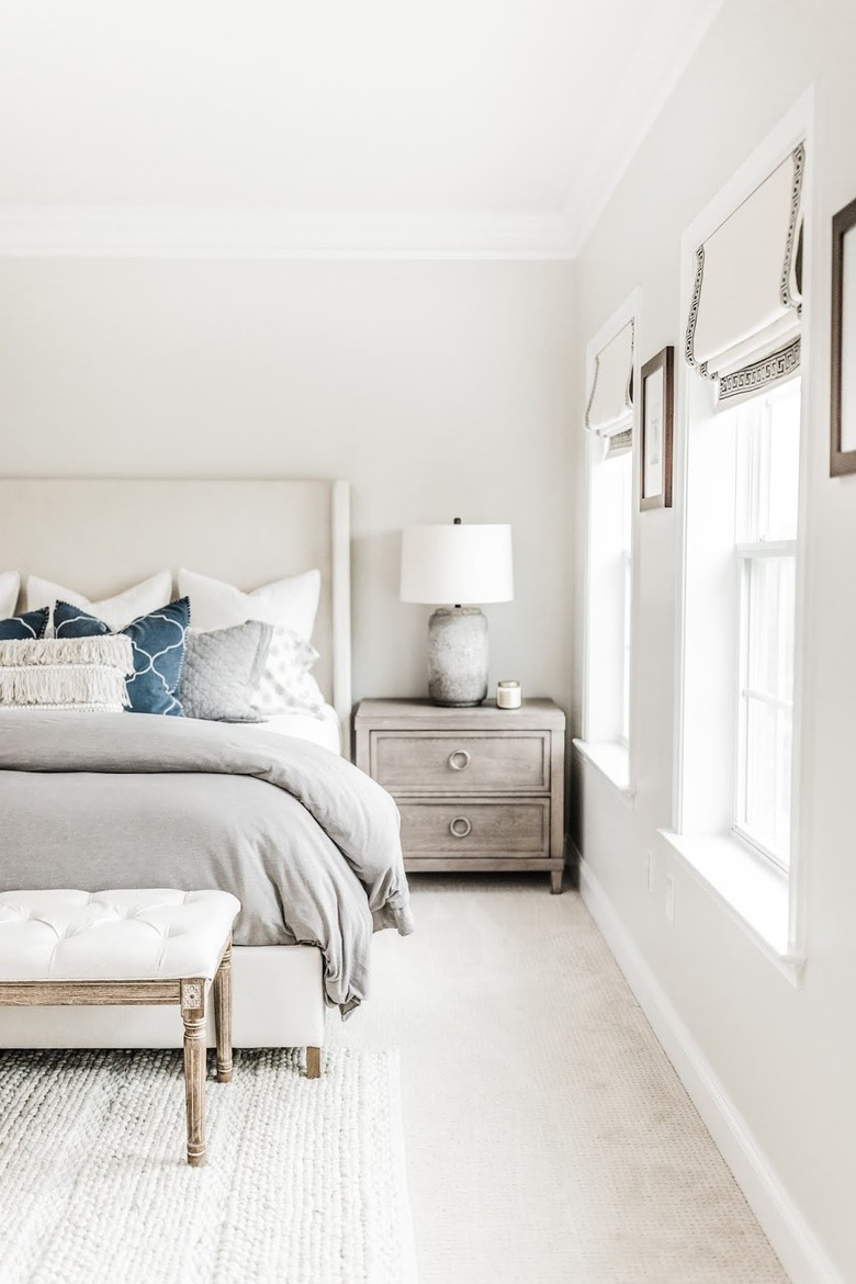 gray cement lamp on top of washed wooden dresser in guest bedroom