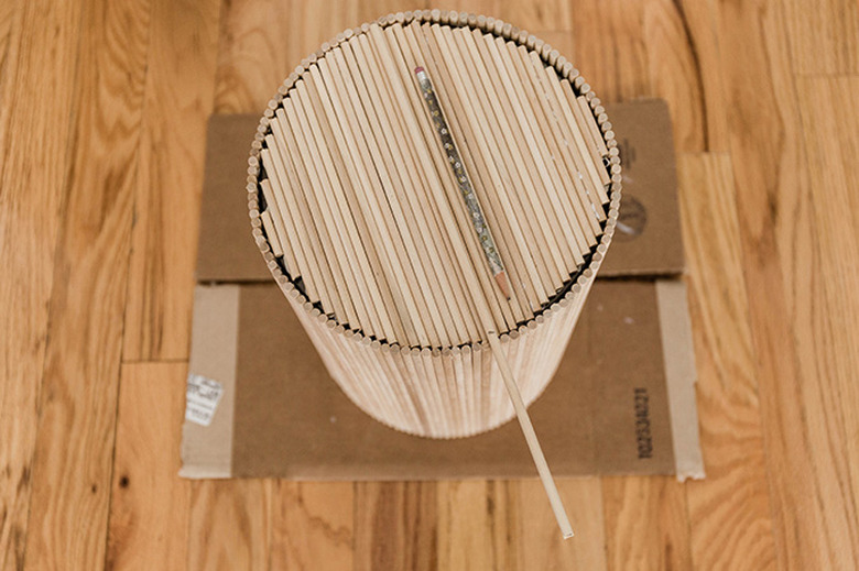 Cut dowel rods to cover the top of the trash can