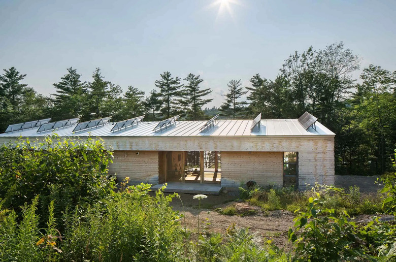 Modern prefab home with solar panels surrounded by trees