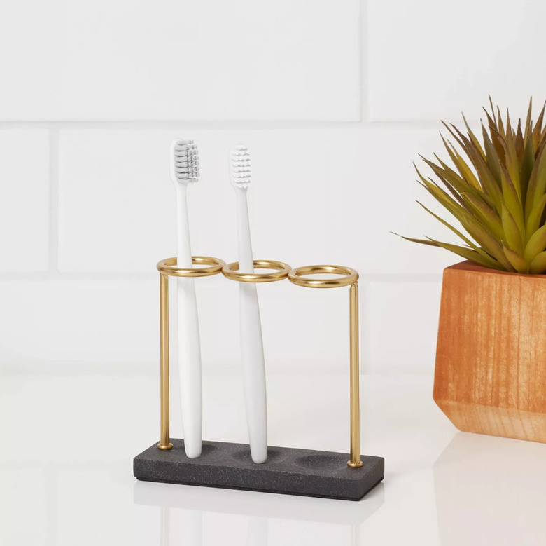 Gold and black toothbrush holder with white toothbrushes