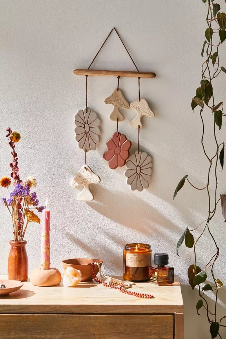 dresser with items and hanging ceramic wall art