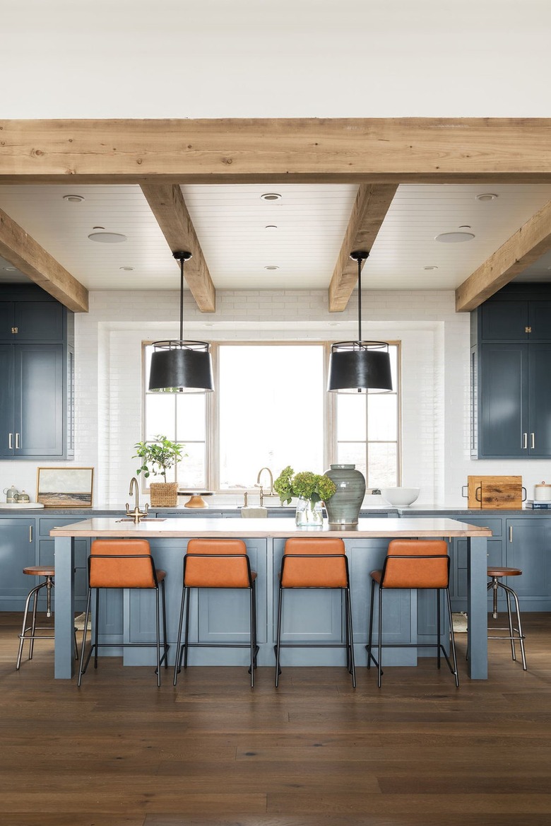 light navy blue kitchen with cognac bar stools around island