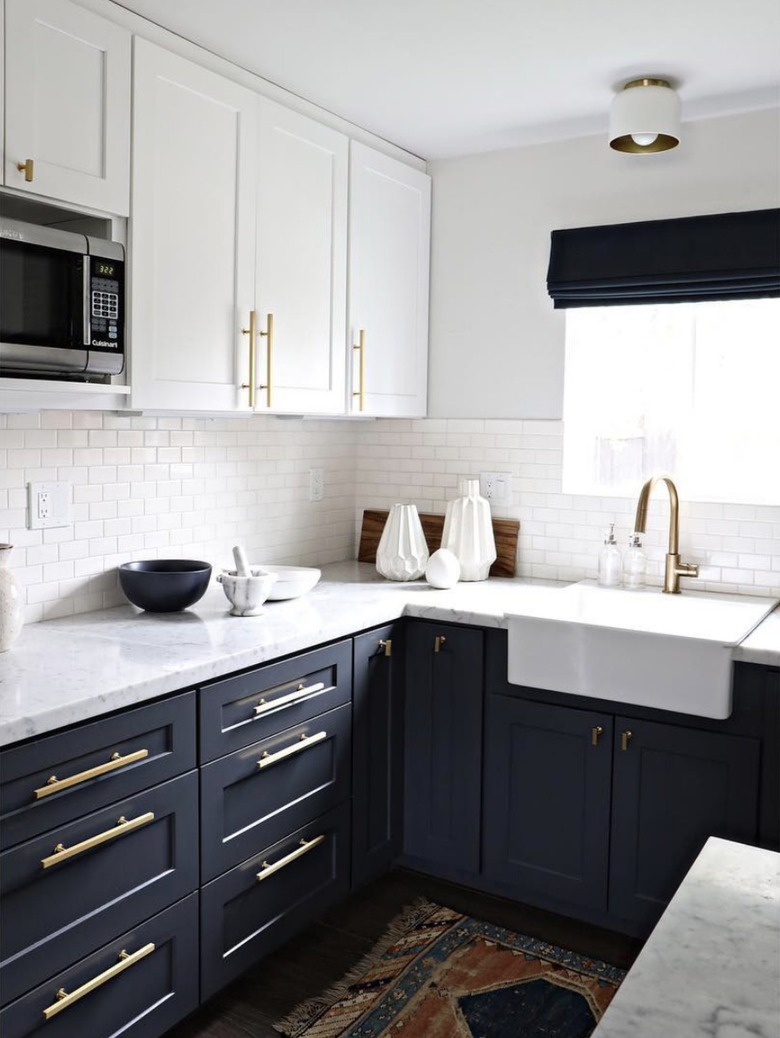 dark navy blue cabinets with vintage rug and white subway tile backsplash