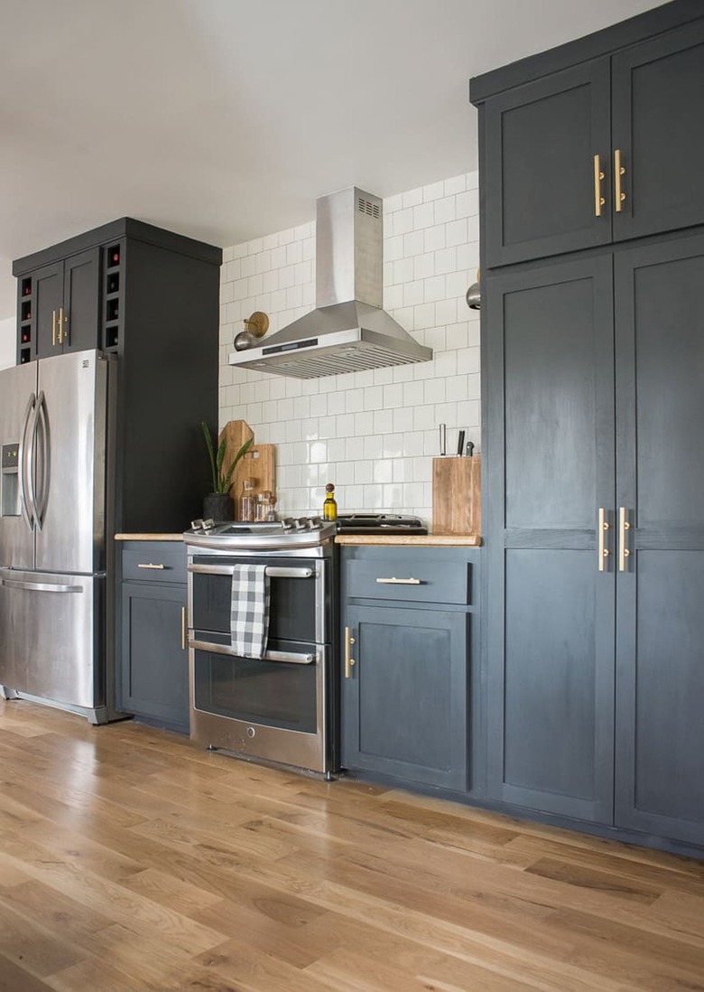navy blue kitchen cabinets with stove and stainless steel appliances