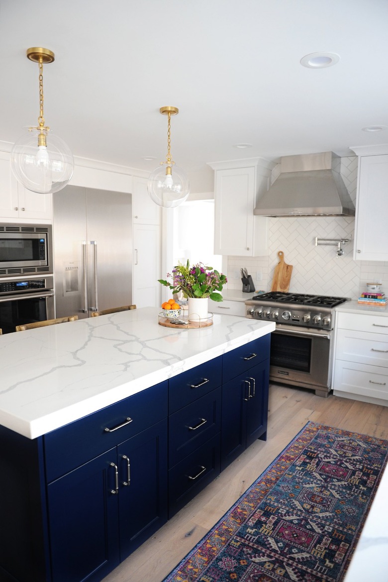 blue kitchen island with white marble top in modern kitchen