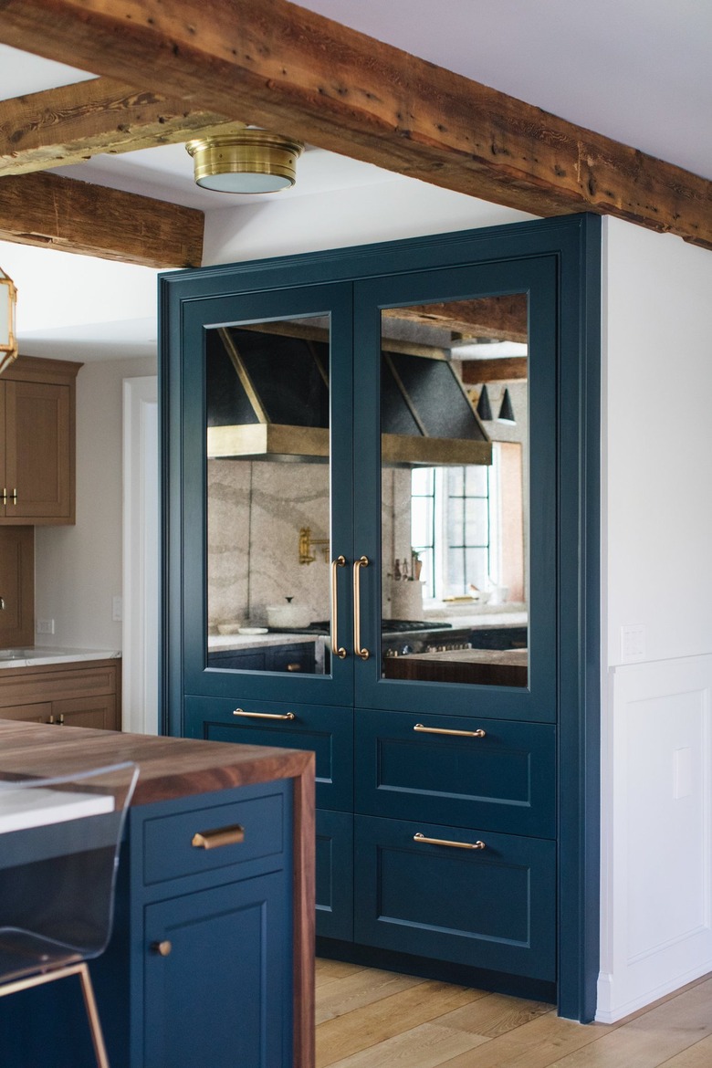navy blue pantry doors with wood beams in white kitchen