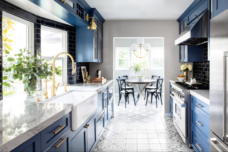 Navy blue kitchen color idea with gold hardware and cement tile floor