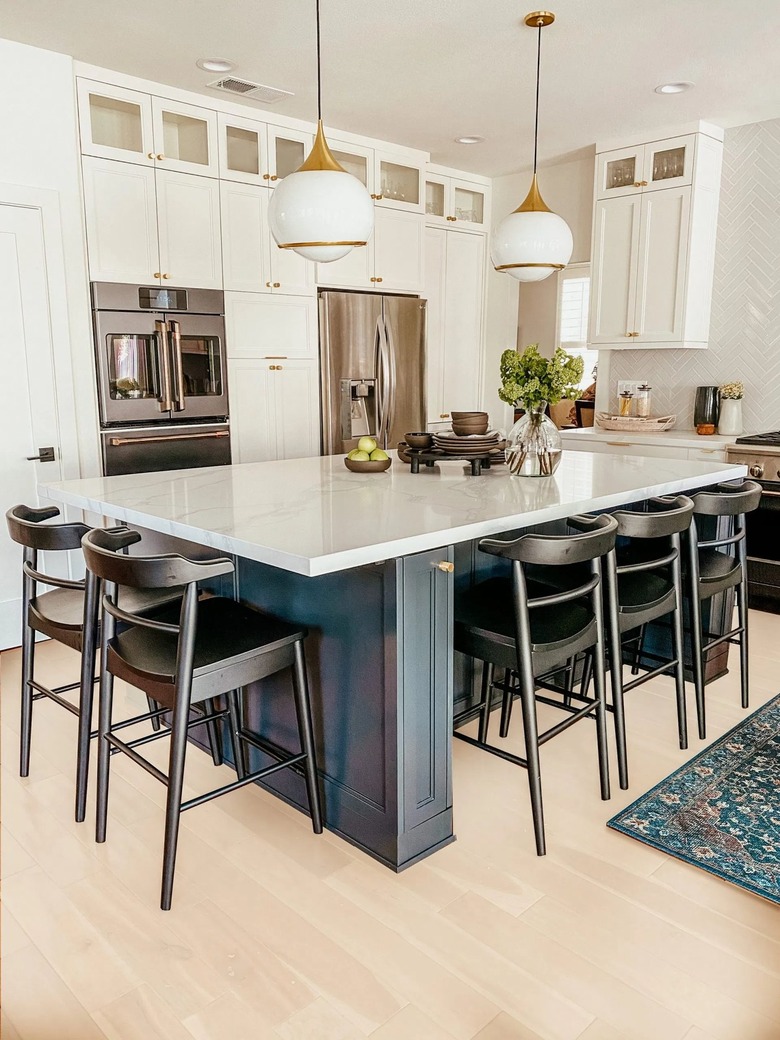 navy blue kitchen island with black chairs with globe pendant lights