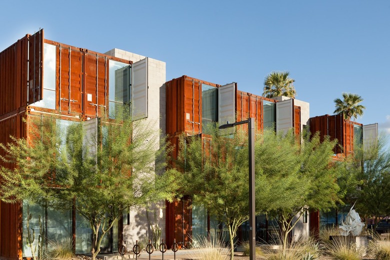 Brown-blue shipping container buildings with trees