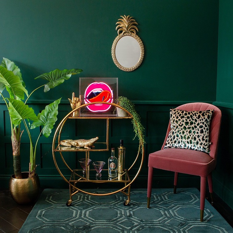 dark living room with neon lips artwork on gold bar trolley