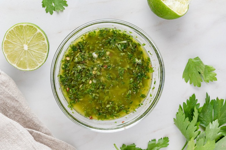 The chimichurri sauce in a clear glass bowl