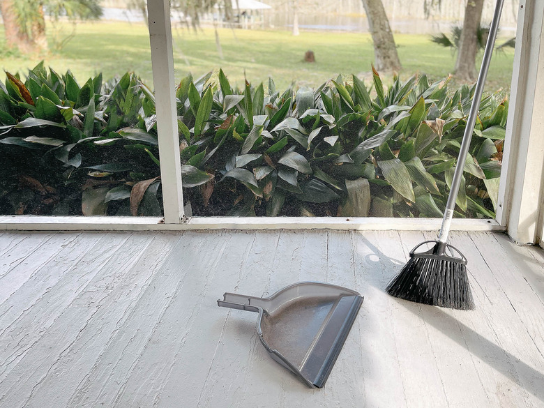 Broom and dustpan on clean sunroom floor