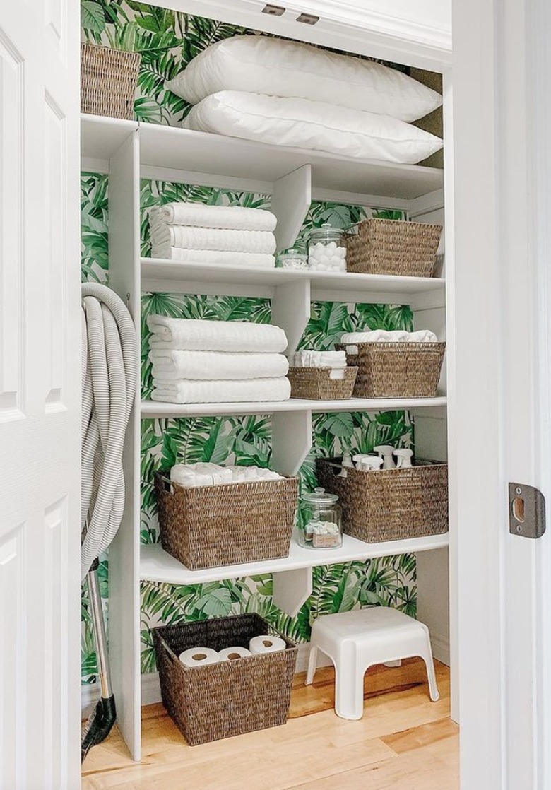 Linen closet with green wallpaper