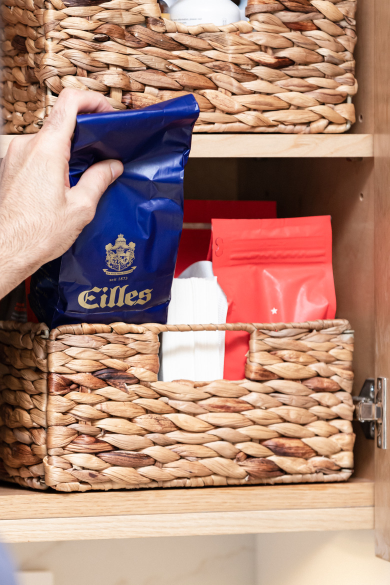 Natural woven baskets holding coffee beans in cabinet