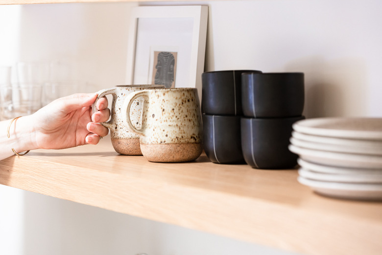 Ceramic mugs on open shelf