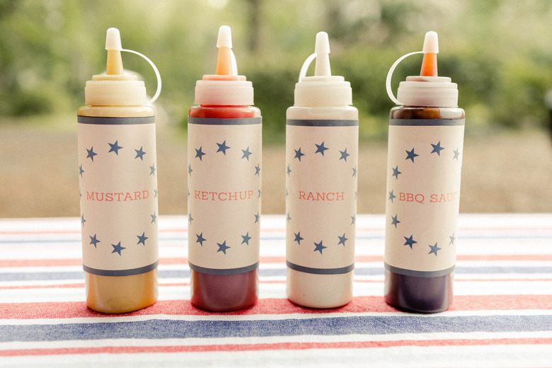 Four hot dog bar condiment bottles with printable labels for mustard