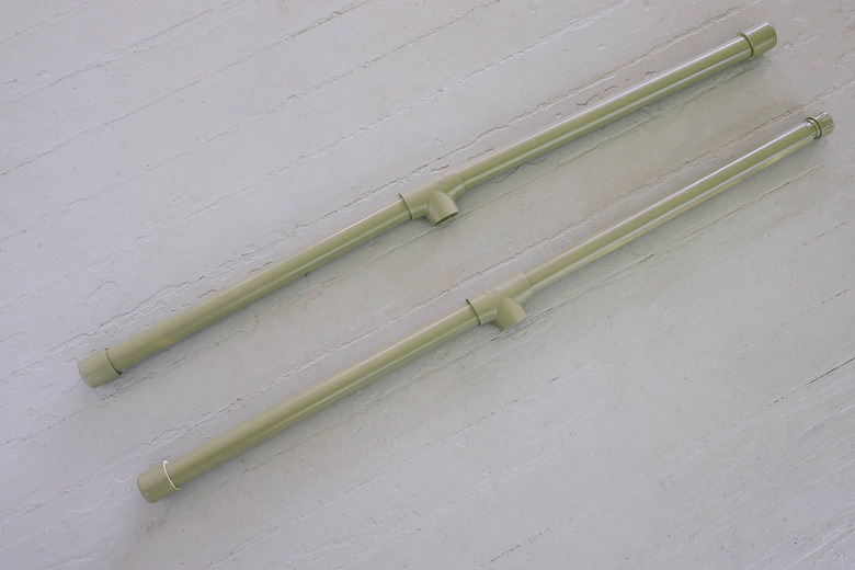 Four PVC pipes connected to tee connectors with end caps and hose adapter on one pipe