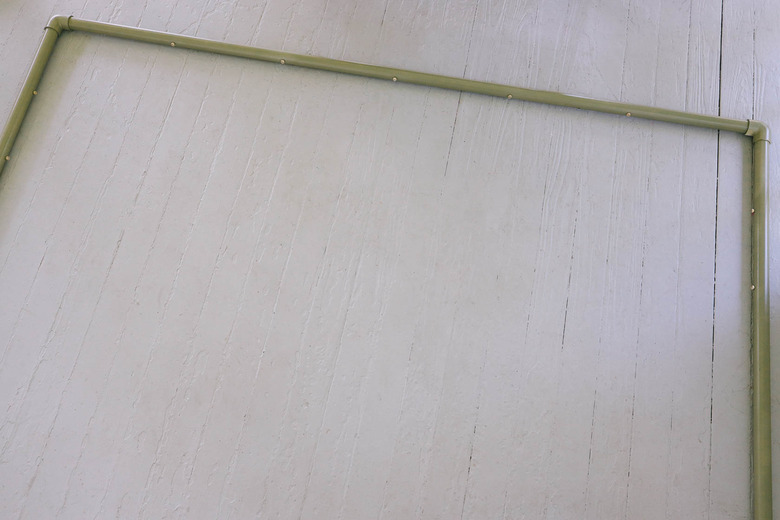 Two vertical PVC pipes attached to horizontal pipe with elbow connectors