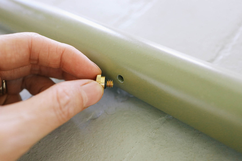 Twisting brass water mister into hole in PVC pipe