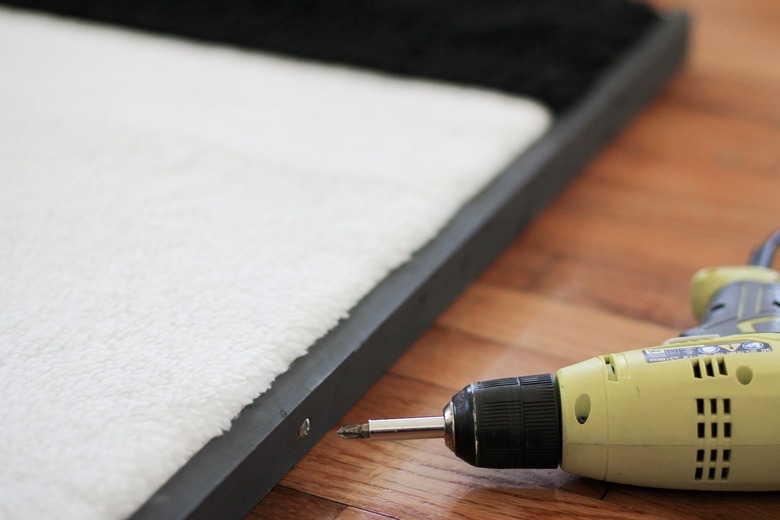 Shearling art with black frame with screw and power drill