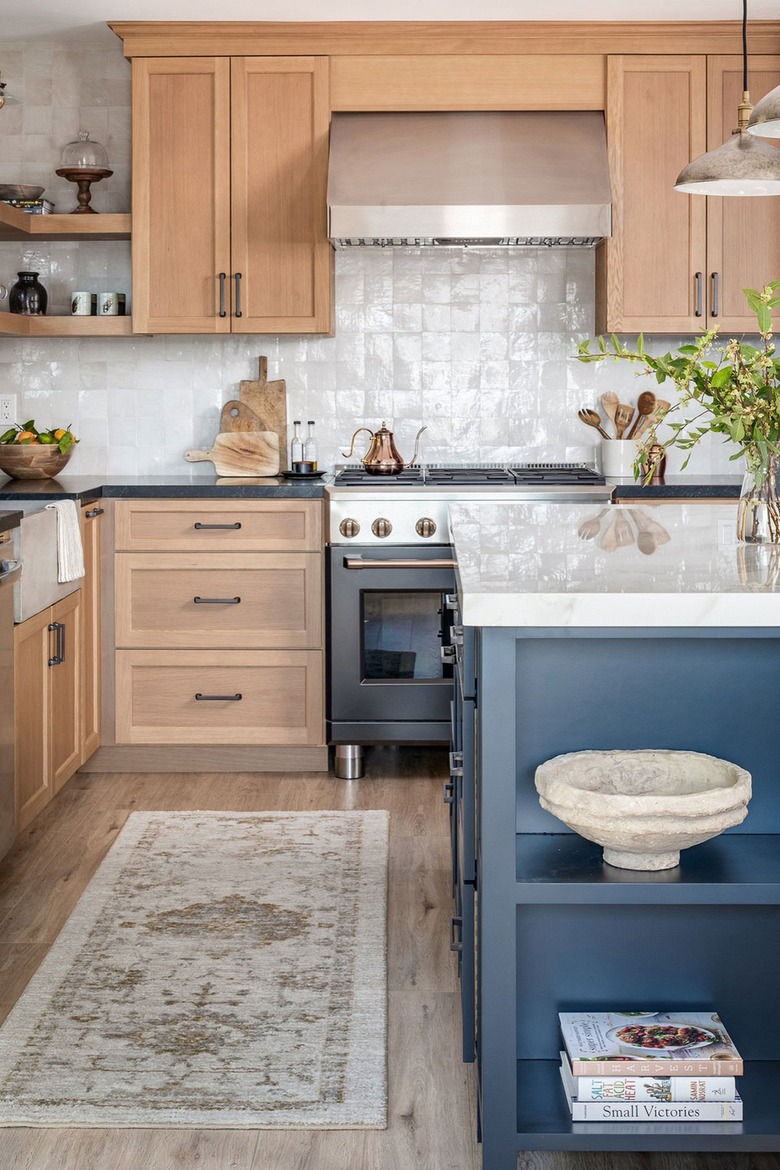 Kitchen with oak cabinets and a blue island.