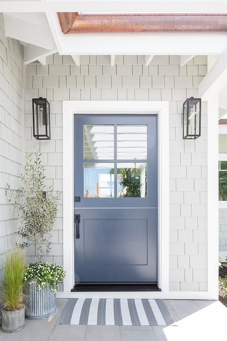 pale gray shingled home with dark gray door