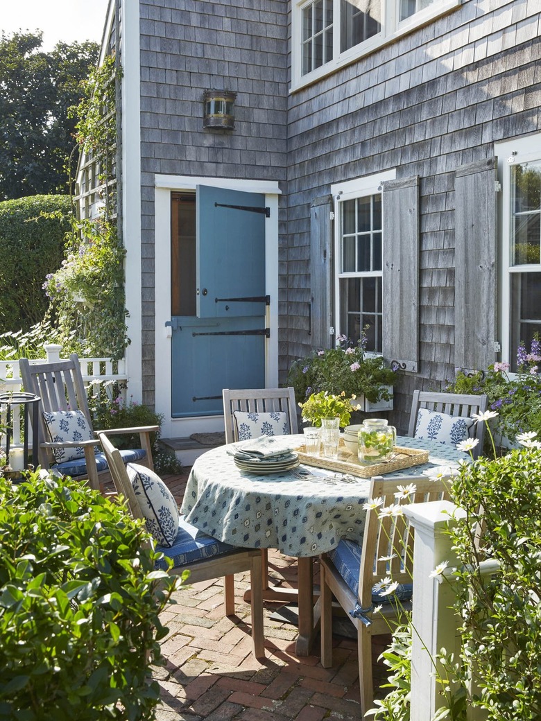 gray shingled home with teal dutch door