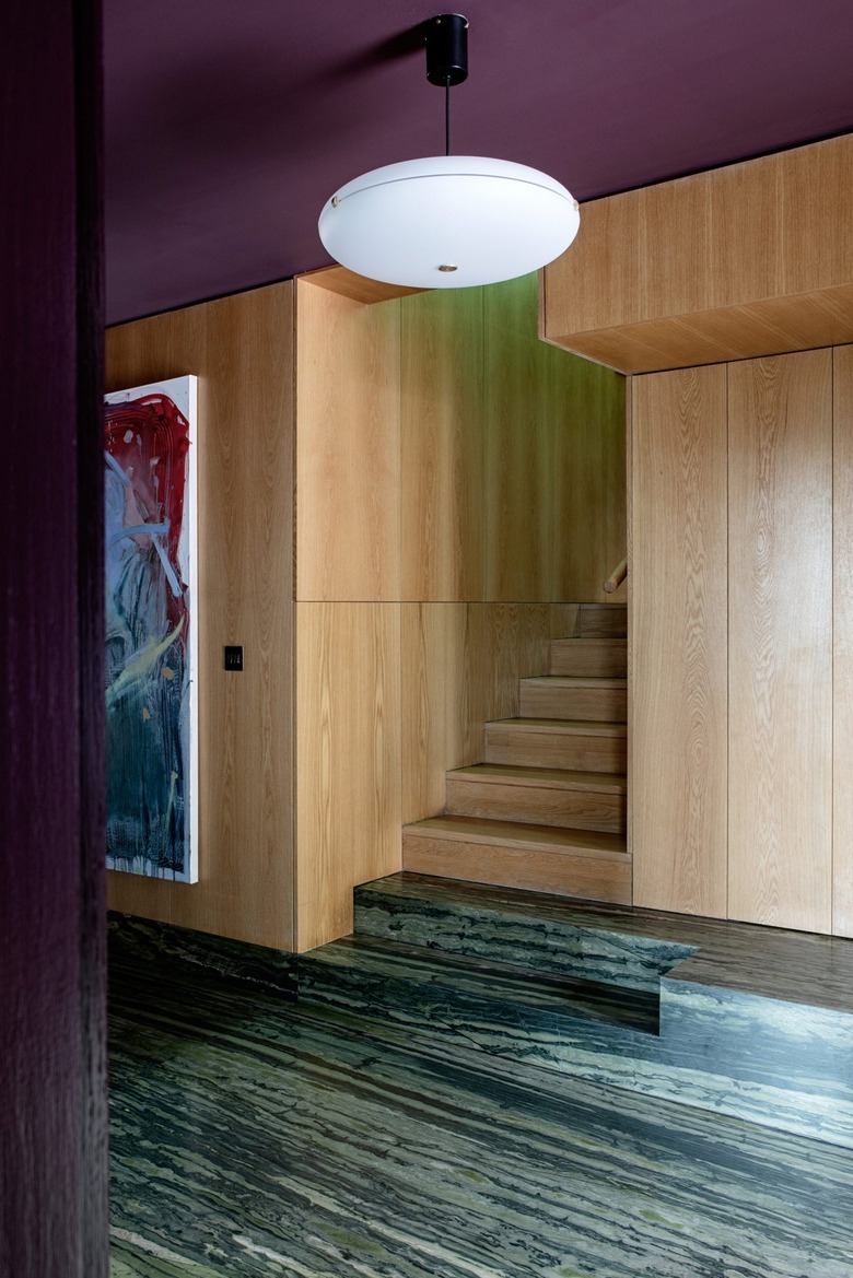 hallway with wood panels and purple paint