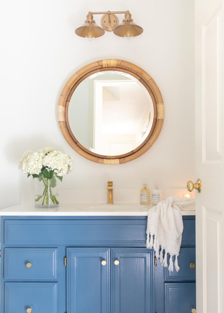 Painted bathroom cabinets before and after featuring nautical decor and blue cabinets