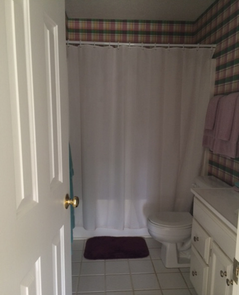 Painted bathroom cabinets before and after featuring dark accents and white floor tile