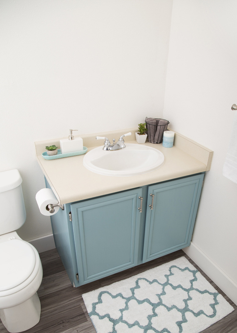 Painted bathroom cabinets before and after featuring light blue cabinets