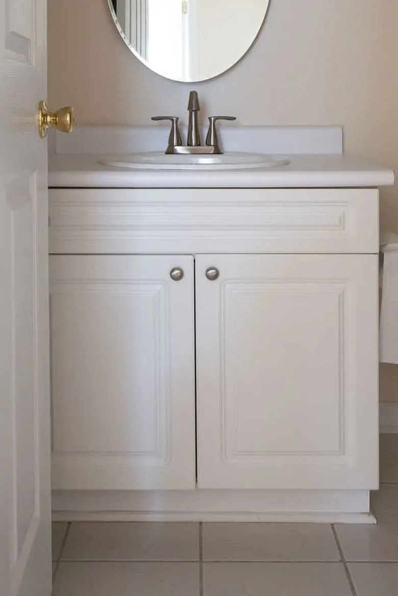Painted bathroom cabinets before and after featuring white vanity