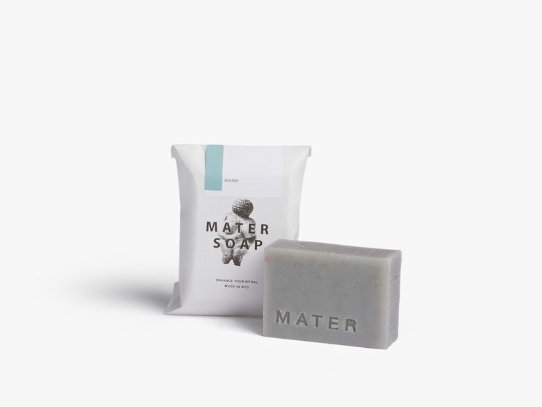 A gray-blue bar of soap next to white packaging that says Mater Soap.